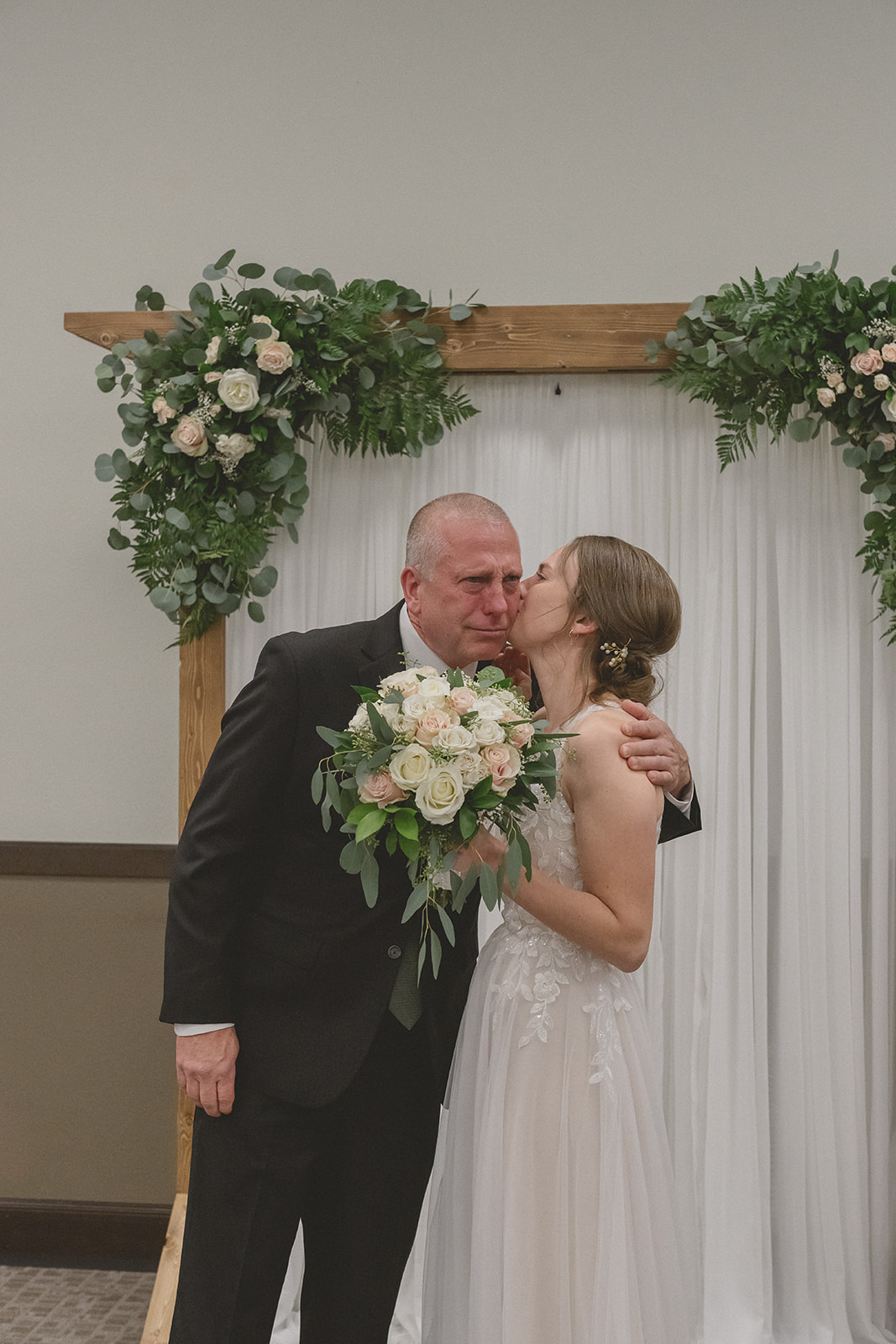 Bride giving a kiss on dad's cheek
